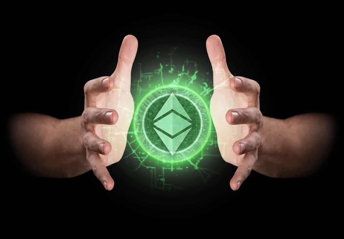 A pair of male hands reaching through the dark grasping at an ethereum hologram