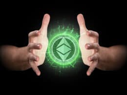 A pair of male hands reaching through the dark grasping at an ethereum hologram